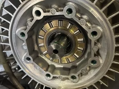 Close-up of brand new rear roller bearing track installed during service on a Nilfisk SH Truck Booster, showing clean and unworn components ready for operation.